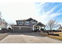 Stunning two-story home showcasing a four-car garage, covered porch, and lush landscaping at 1168 Coneflower Way, Brighton, CO 80601