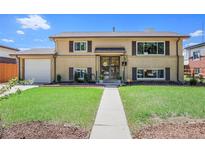 Charming two-story home featuring a brick and siding exterior, manicured lawn, and inviting entryway at 3065 Zion St, Aurora, CO 80011