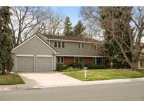 Traditional two-story home with a brick and siding exterior, well-manicured lawn, and a two-car garage at 3821 S Magnolia Way, Denver, CO 80237