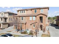 Charming townhome exterior featuring a mix of brick and stucco finishes with a small front yard at 9374 Loggia St # D, Highlands Ranch, CO 80126