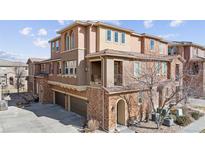 Beautiful townhouse with a brick and stucco exterior, a private balcony, and a two-car garage at 9374 Loggia St # D, Highlands Ranch, CO 80126
