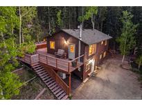 Rustic cabin with a spacious deck nestled in a serene forest setting, perfect for outdoor living at 375 Castlewood Dr, Evergreen, CO 80439