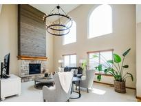 Bright living room features a fireplace, two-story ceilings, and updated modern lighting at 4320 Stone Post Dr, Castle Rock, CO 80108