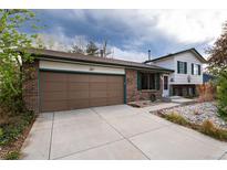 Charming brick home featuring an attached garage and well-kept front yard and inviting curb appeal at 4917 S Xenophon Way, Morrison, CO 80465