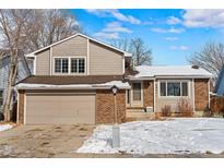 Charming two-story home with a brick and siding exterior, complemented by a well-manicured lawn at 884 Elliott St, Longmont, CO 80504