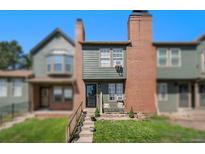 Two-story townhouse with well-maintained lawn and two chairs on the porch at 17111 E Stanford Ave # C, Aurora, CO 80015