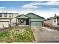Charming single Gathering home with a well-manicured lawn, covered porch, and two-car garage at 316 Maple St, Bennett, CO 80102