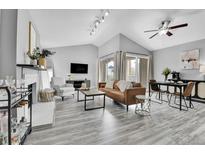Bright living room with vaulted ceilings, modern furniture, fireplace, and sliding glass doors to a balcony at 3331 S Monaco Pkwy # C, Denver, CO 80222
