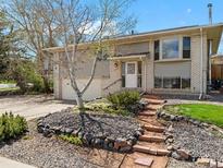 Charming home featuring a blend of brick and siding, complemented by a well-manicured front yard at 13223 W Utah Cir, Lakewood, CO 80228