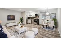 Open concept living area with modern finishes, stainless steel appliances, and eat-in dining space at 5875 E Iliff Ave # 108, Denver, CO 80222