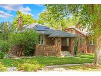 Charming brick home with well-maintained lawn, solar panels, and inviting curb appeal at 2271 Holly St, Denver, CO 80207