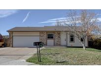 Charming single-story home with brick accents, a well-maintained lawn, and an attached two-car garage at 265 Cleveland Ct, Bennett, CO 80102