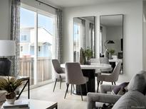 Bright dining area featuring a modern round table and gray chairs by a sliding glass door at 249 E 4Th St, Berthoud, CO 80513