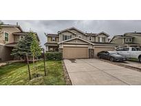 Two-story home with a two-car garage, landscaped front yard, and neutral-colored exterior with a paved driveway at 5653 Raleigh Cir, Castle Rock, CO 80104