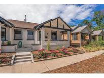 Charming white brick home with a cozy front porch and vibrant rose bushes at 2925 E 14Th Ave, Denver, CO 80206