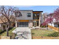 Beautiful two-story home featuring modern architecture, a glass garage door and a well-manicured front yard at 3485 S Clermont St, Denver, CO 80222