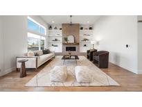 Bright living room featuring a brick fireplace, built-in shelves, and modern furnishings at 3485 S Clermont St, Denver, CO 80222