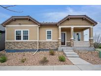 Charming single-story home featuring stone accents and a welcoming front porch, located at 13275 at 13275 E Caley Pl, Centennial, CO 80111