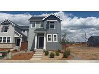 Charming two-story home with gray siding and white trim, complemented by fresh landscaping at 2087 Generations Aly, Brighton, CO 80601