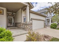 Charming home featuring stone accents on the porch columns and attached two-car garage at 9724 Crowsley Ct, Parker, CO 80134