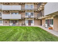 A charming, multi-story apartment building featuring well-maintained landscaping and a grassy courtyard at 384 S Ironton St # 208, Aurora, CO 80012