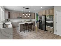 Bright kitchen featuring modern appliances, a marble island and quartz countertops at 7119 S Riviera St, Aurora, CO 80016