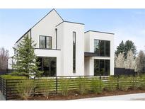 Striking modern home featuring a bright white facade, black framed windows and a minimalist landscape at 1001 S Adams St, Denver, CO 80209