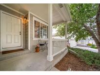 Inviting front porch with cozy seating area and well-maintained landscaping at 20738 E Grand Pl, Aurora, CO 80015