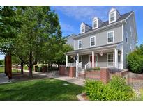 Charming two-story home boasts a classic gray exterior, inviting front porch, manicured lawn, and well-kept landscaping at 8171 E 33Rd Ave, Denver, CO 80238