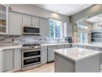 Modern kitchen featuring stainless steel appliances, gray cabinetry and a bright, window-lit space at 10609 Abilene St, Commerce City, CO 80022