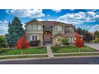 Beautiful two-story home with a well-maintained lawn, mature trees, and inviting front entrance at 15723 E Orchard Pl, Aurora, CO 80016