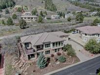 Beautiful exterior of the home featuring stone accents, landscaped yard, and a private balcony with scenic views at 5951 Rain Dance Trl, Littleton, CO 80125