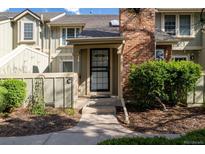 Charming townhouse with a brick chimney, covered entry and landscaped garden area at 7761 S Curtice Dr # C, Littleton, CO 80120