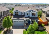Charming two-story home with blue siding, well-manicured lawn, and an attached two-car garage in a suburban neighborhood at 10057 Des Moines St, Parker, CO 80134