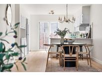 Bright dining area featuring a round table, modern chandelier, and access to the kitchen at 7050 W Cedar Ave # 108, Lakewood, CO 80226