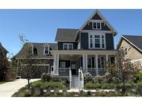 Charming two-story home boasts a welcoming front porch and beautiful landscaping, adding to its curb appeal at 6023 Chester Way, Denver, CO 80238