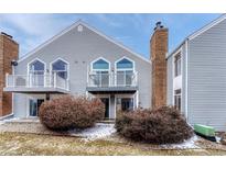 Two-story townhome featuring a chimney and upper level decks with white railing at 3337 S Monaco Pkwy # C, Denver, CO 80222