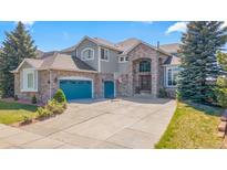 Charming two-story home with a brick facade, arched entry, and three car garage at 24022 E Jamison Dr, Aurora, CO 80016