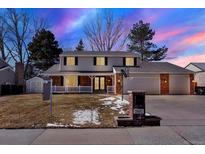 Charming two-story home with a well-manicured lawn, inviting front porch and attached two car garage at 7631 Oak St, Arvada, CO 80005