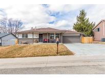 Charming single-story home featuring a well-maintained front yard and attached two-car garage at 6343 Depew St, Arvada, CO 80003