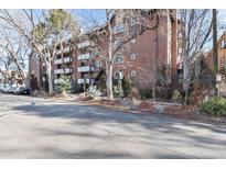 Brick apartment building with balconies and mature trees under a sunny, clear blue sky at 1270 N Marion St # 505, Denver, CO 80218