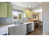 Updated kitchen features stainless steel appliances, sleek countertops, and a window offering natural light at 3700 Zenobia St, Denver, CO 80212