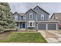 Charming two-story home with a manicured lawn, blue accents, and a spacious two-car garage at 8862 Chestnut Hill Ln, Highlands Ranch, CO 80130