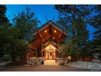 Unique home entrance featuring antlers above the covered stone entryway with wood beam construction and front door at 33208 Alta Vista Dr, Evergreen, CO 80439