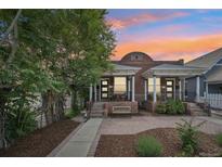 Charming brick home with a well-manicured front yard and a cozy front porch at 3444 Lawrence St, Denver, CO 80205