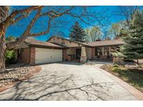 Charming single-story home with brick accents, mature trees, and a spacious driveway and entry at 5000 S Chester St, Greenwood Village, CO 80111