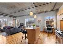 Bright living space with modern kitchen island, hardwood floors, and exposed ceiling elements at 1499 Blake St # 3O, Denver, CO 80202