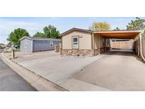 Tan home featuring stone accents, and a covered carport in a lovely neighborhood at 8426 Cook Way, Denver, CO 80229