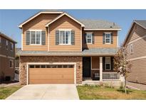 Charming two-story home with stone accents, attached garage, and welcoming front porch at 3567 E 140Th Dr, Thornton, CO 80602