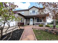 Charming home featuring stone accents, well-maintained landscaping, and a welcoming front porch at 3530 Doolittle Rd, Monument, CO 80132